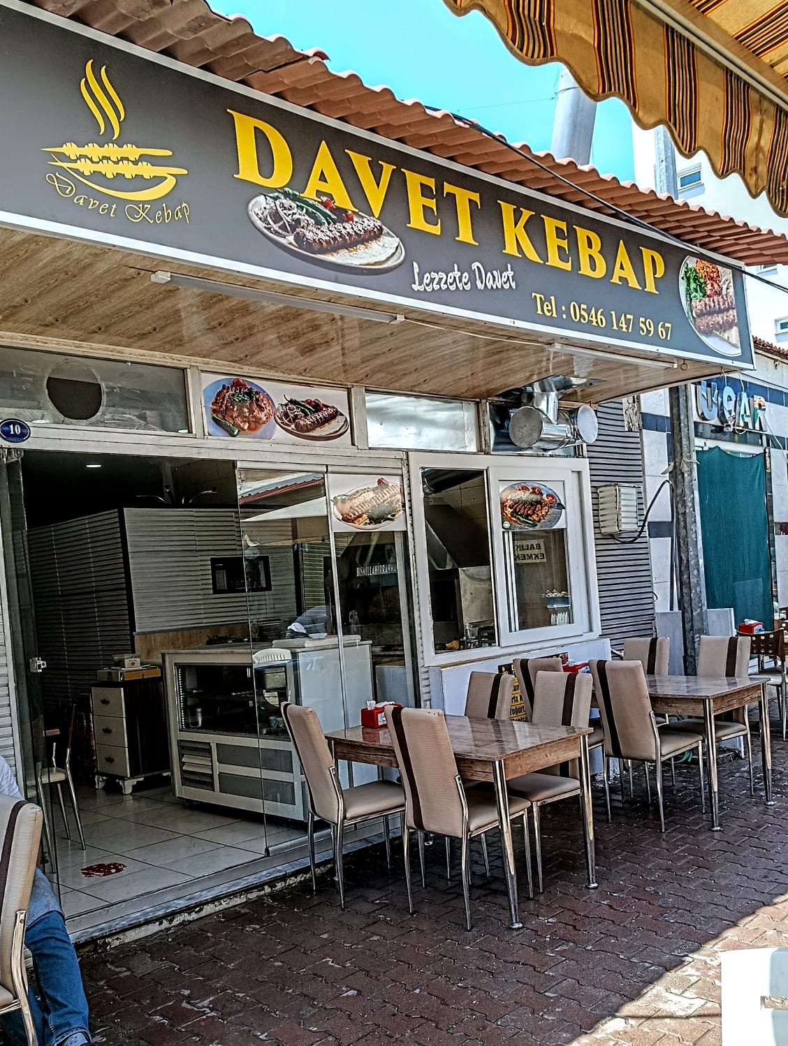 Davet Kebap dış cephesi — sarı tabela ve dış mekân oturma alanı, Çandarlı